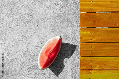 Watermelon with yellow deckchair on concrete floor