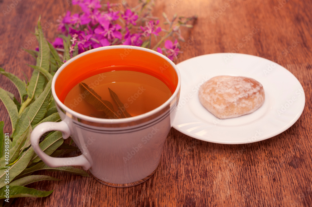 Still life photo with herbal tea from fireweed leaves and gingerbread on a wooden background Still life photo with herbal tea from fireweed leaves and gingerbread on a wooden background