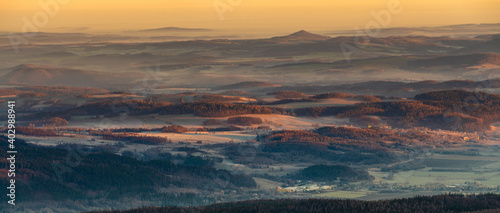 Panorama of a mountain valley shrouded in morning mists seen from the top of the Karkonosze mountain range in Poland photo