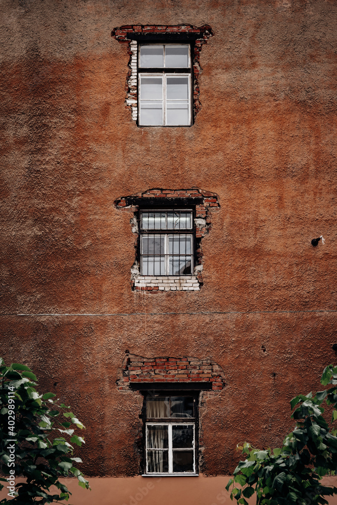 Wall of an old house with three windows