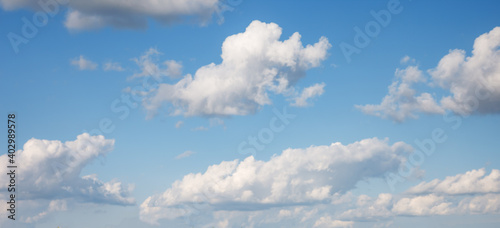 Idyllic blue sky with white fluffy clouds in sunny day.