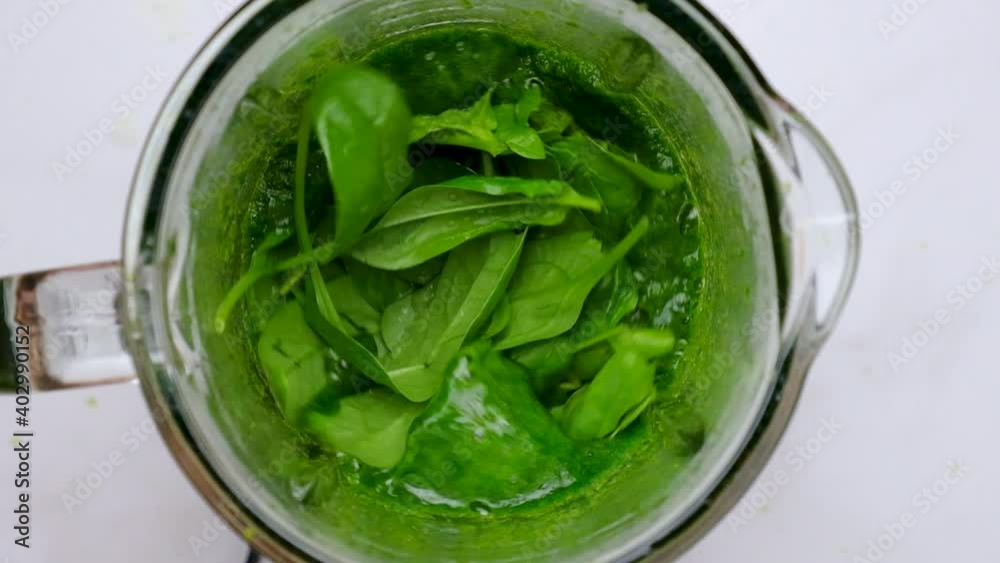 Green spinach smoothie blended in blender. top view. slow motion. Healthy diet detox drink