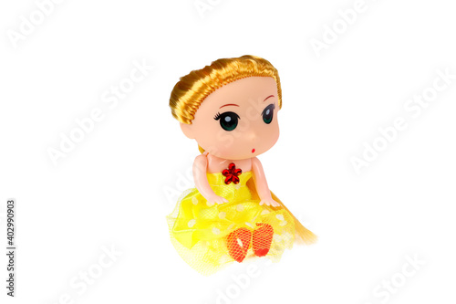 A doll in a yellow dress. On a white background  isolated.
