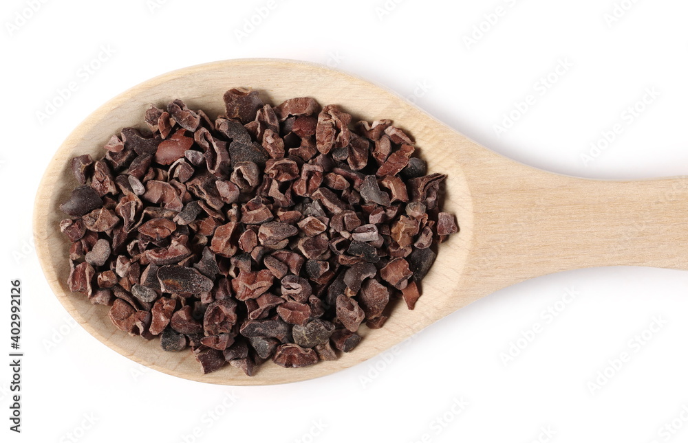 Chopped, grated cocoa pieces in wooden spoon isolated on white background, top view Chopped, grated cocoa pieces in wooden spoon isolated on white background, top view