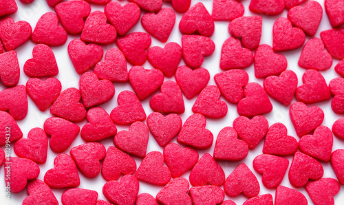 Red Hearts Candy on white surface close up. Valentine's day concept. Macro. Sweet red candy texture
