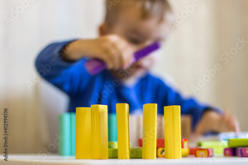 Little boy playing in colored wooden bars