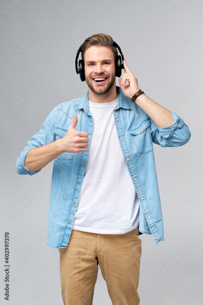 Close up portrait of cheerful young man enjoying listening to music wearing casual jeans outfit Close up portrait of cheerful young man enjoying listening to music wearing casual jeans outfit