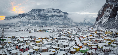 scenic view of village against snow covered mountains. Village of Mezzocorona, Trento province, Trentino Alto Adige, northern Italy. winter lanscape photo