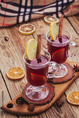 Mulled wine with cinnamon sticks and orange on the old wooden table