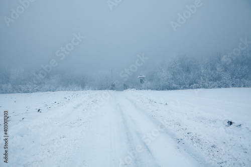 Snowy road in the winter day . Hard road in the Foggy Day 