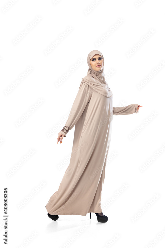 Light. Beautiful arab woman posing in stylish hijab isolated on studio background with copyspace for ad. Fashion, beauty, style concept. Female model with trendy make up, manicure and accessories.