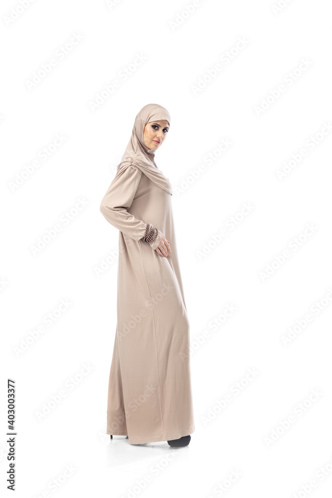Rich. Beautiful arab woman posing in stylish hijab isolated on studio background with copyspace for ad. Fashion, beauty, style concept. Female model with trendy make up, manicure and accessories. Rich. Beautiful arab woman posing in stylish hijab isolated on studio background with copyspace for ad. Fashion, beauty, style concept. Female model with trendy make up, manicure and accessories.