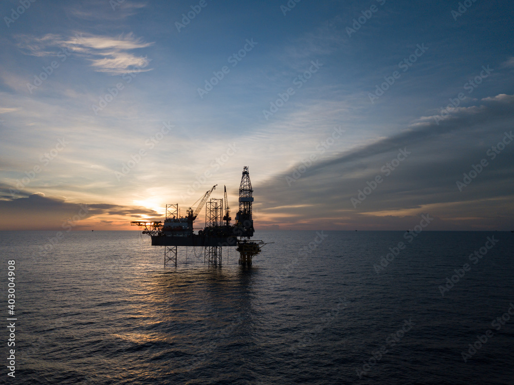 Aerial view offshore drilling rig (jack up rig) at the offshore location during sunset