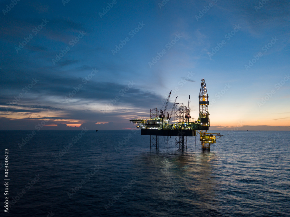 Aerial view offshore drilling rig (jack up rig) at the offshore location during sunset