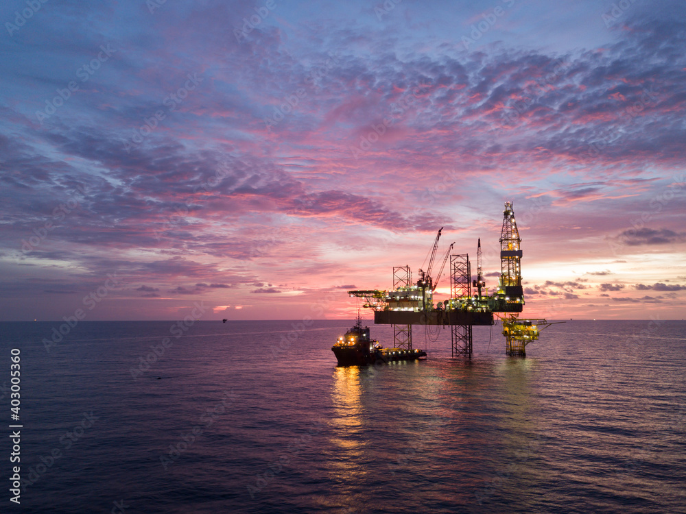 Aerial view offshore drilling rig (jack up rig) at the offshore location during sunset