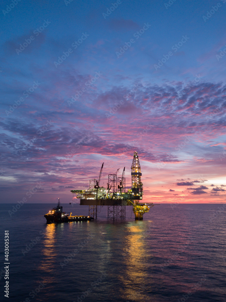 Aerial view offshore drilling rig (jack up rig) at the offshore location during sunset