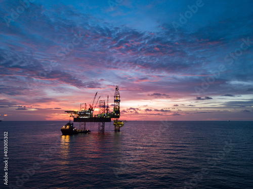 Aerial view offshore drilling rig (jack up rig) at the offshore location during sunset