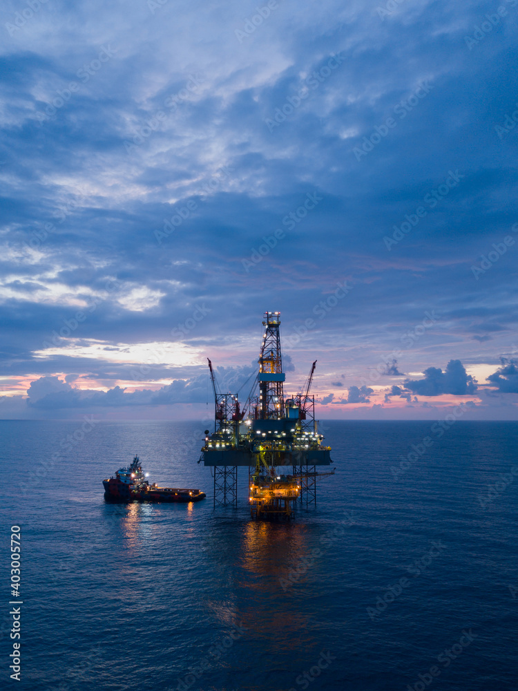 Aerial view offshore drilling rig (jack up rig) at the offshore location during sunset Aerial view offshore drilling rig (jack up rig) at the offshore location during sunset