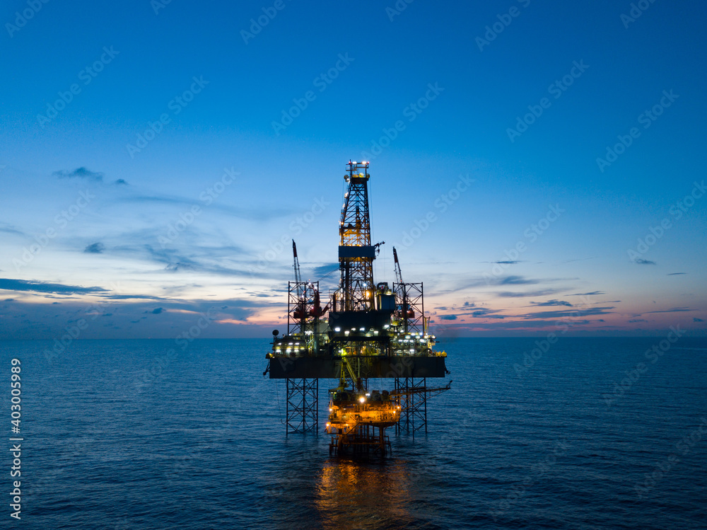 Aerial view offshore drilling rig (jack up rig) at the offshore location during sunset