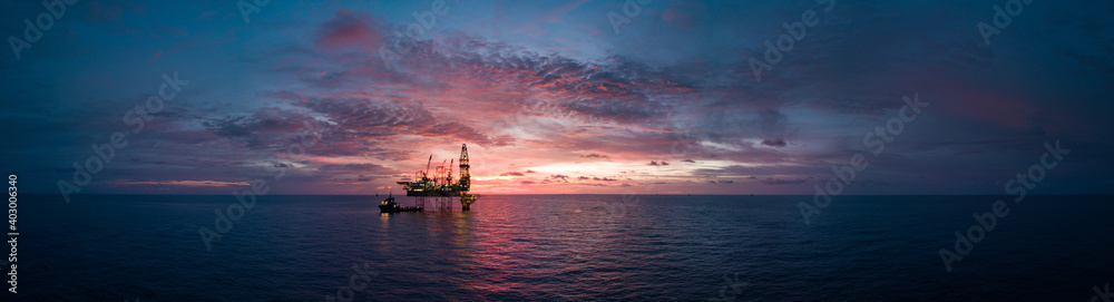 Aerial panorama view from a drone of an offshore jack up rig during sunset time at the offshore location