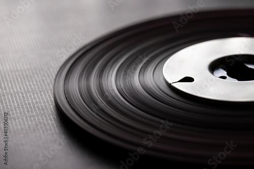 A vintage audio tape reel on black background