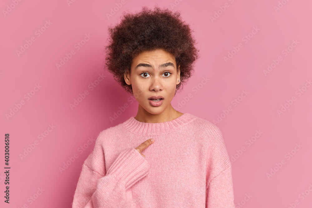 Puzzled indignant woman points at herself asks why do you blame me being accused by someone wears casual jumper isolated over pink background. Displeased African American female insulted or questioned Puzzled indignant woman points at herself asks why do you blame me being accused by someone wears casual jumper isolated over pink background. Displeased African American female insulted or questioned