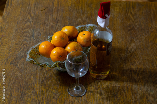 Exposition - a vase with tangerines, Bakal and a bottle of wine. photo