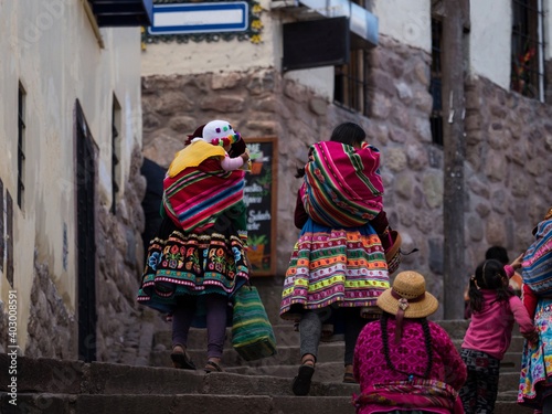 Indigenous quechua women in traditional colorful handwoven textile clothing dress costume walking in Cusco Peru photo