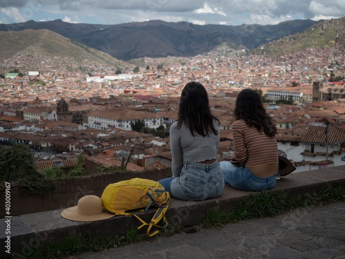 Female tourists on Plaza San Cristobal viewpoint overlooking historical city center downtown Cusco Peru South America