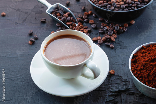 .Roasted coffee beans with coffee powder and coffee cups.