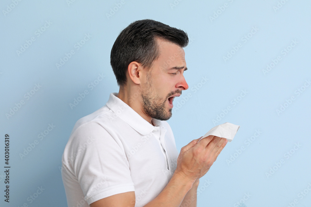 Ill man with runny nose on color background Ill man with runny nose on color background
