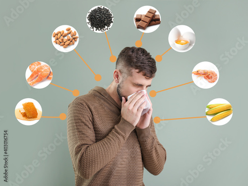 Young man suffering from food allergy on grey background photo