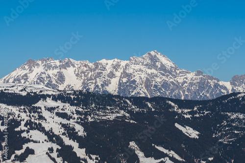Snowy mountain peaks in the Zell am See area of Austria. In the background is a blue sky with dramatic clouds. © Roman Bjuty