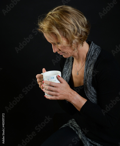 FRAU TRINKT  aus tasse heißgetränk lowkey schatten dunkel hintergrund kaffeee cappucion glühwein kalt, winter photo