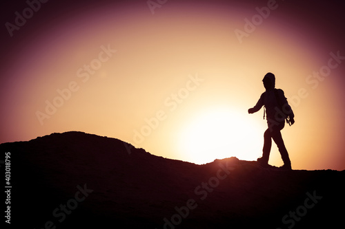 Backpacker hking on sunset desert