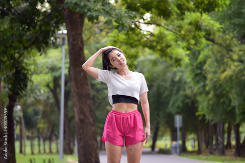 Asian woman is warm up, To make the muscles flexible Before going to jogging for good health and energy metabolism,Outdoors cross training workout. Healthcare concept © NITIKAN T.