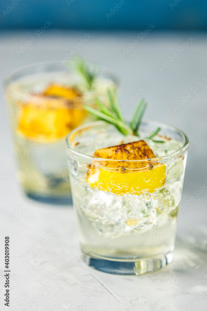 Charred Lemon, Rosemary and Coriander Gin and Tonic is a flavors are perfectly balanced refreshing cocktail. on light background, close up. Summer drinks and alcoholic cocktails Charred Lemon, Rosemary and Coriander Gin and Tonic is a flavors are perfectly balanced refreshing cocktail. on light background, close up. Summer drinks and alcoholic cocktails