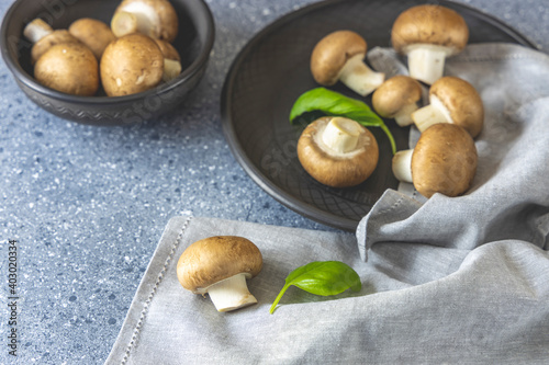 Raw mushrooms champignons on grey background, cooking fresh champignons