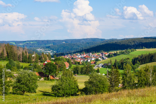 Scenic view of the small German village of Schonach in the Black Forest of Germany. Dark forests and fresh green meadows surround that beautiful village. photo