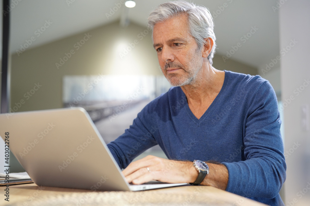 Portrait of senior man at home working on laptop Portrait of senior man at home working on laptop