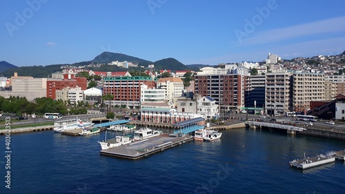 Cruise ship port in the downtown. Photo taken from the top deck of the leaving ship in Nagasaki, Japan  © Pigeon