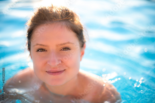 Young woman portrait in swimming pool. Copy space