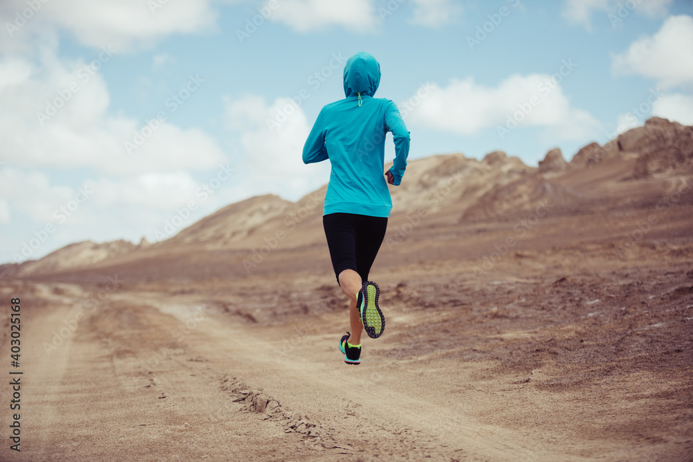 Fitness woman trail runner cross country running on sand desert Fitness woman trail runner cross country running on sand desert