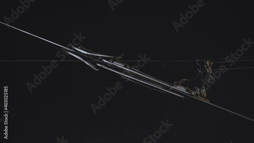 Close-up of a tram power line through which a tram pantograph passes sparks at night. Several options.