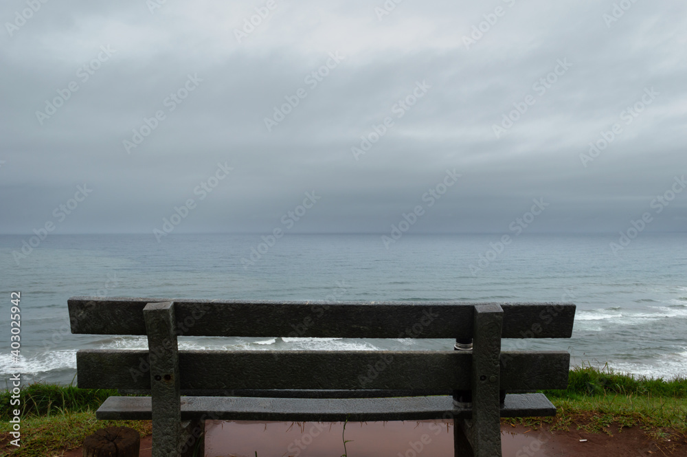 Fototapeta premium Empty bench front the sea, back view
