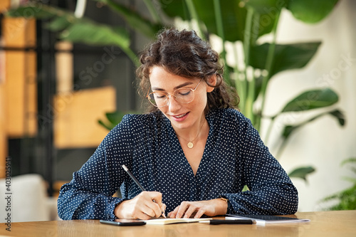 Woman writing down notes on agenda photo