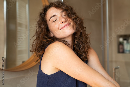Woman stretching in bathroom after wake up photo