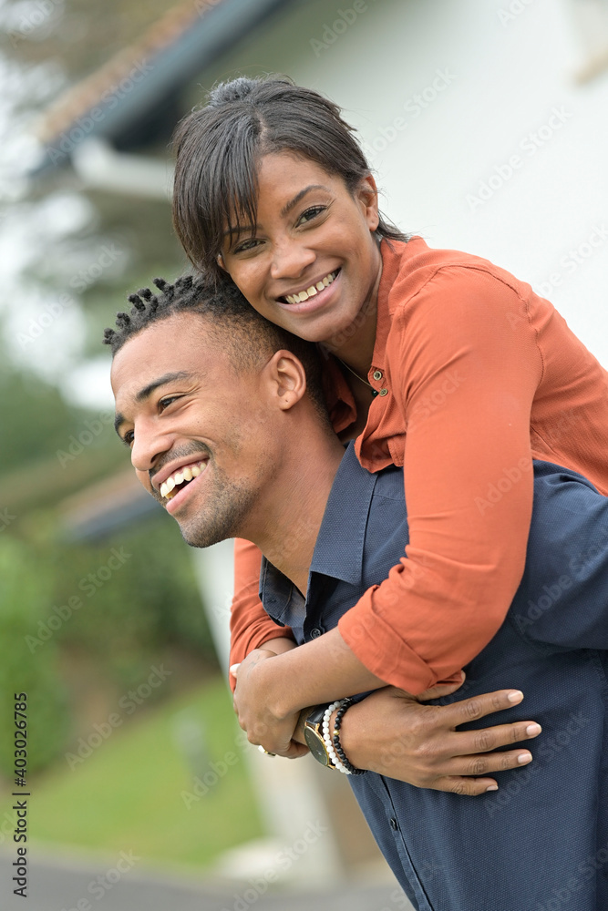 Portrait of happy mixed raced couple standing outside the house Portrait of happy mixed raced couple standing outside the house