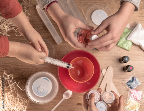 Kids hands making slime toy at home