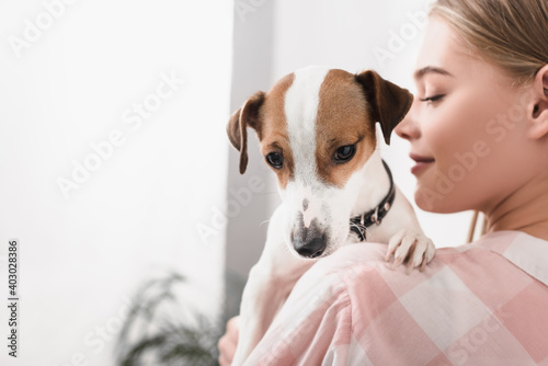 blurred cheerful woman holding in arms jack russell terrier